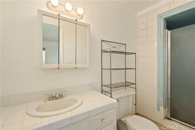 a bathroom with a sink toilet vanity and shower