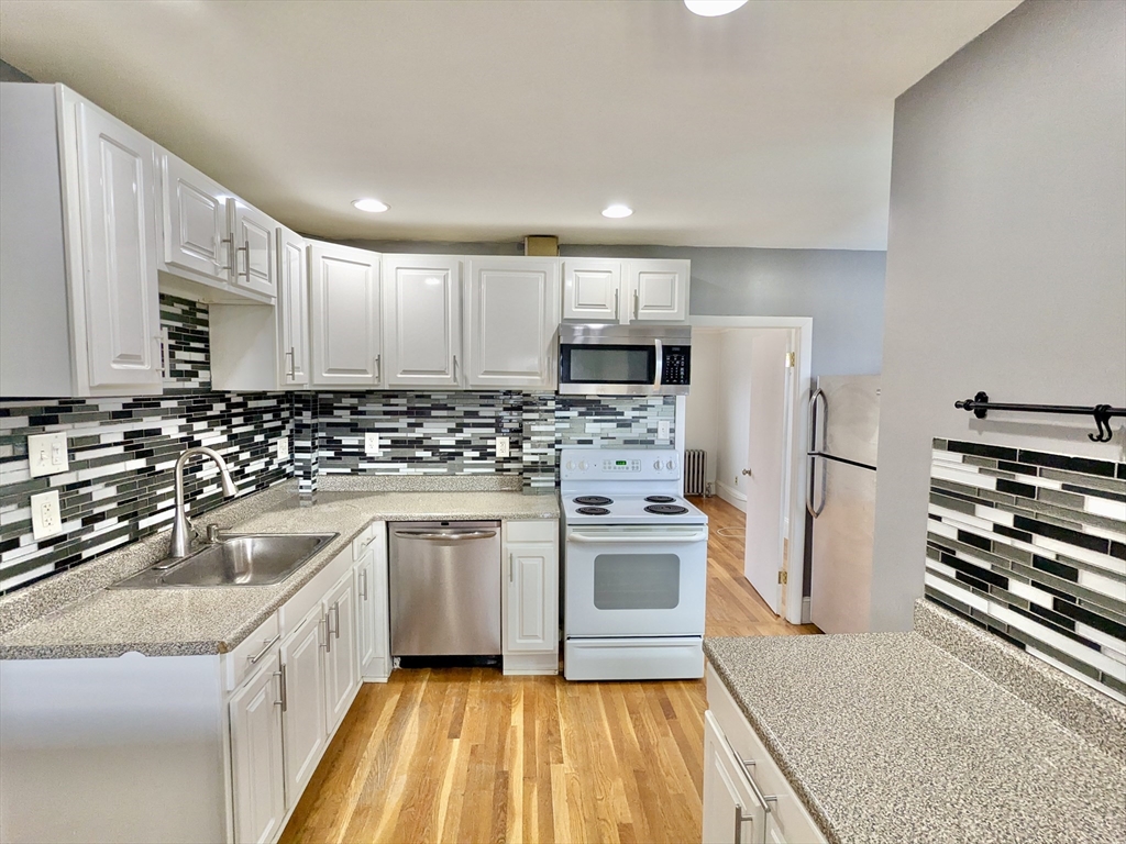 a kitchen with a sink a stove a refrigerator and cabinets