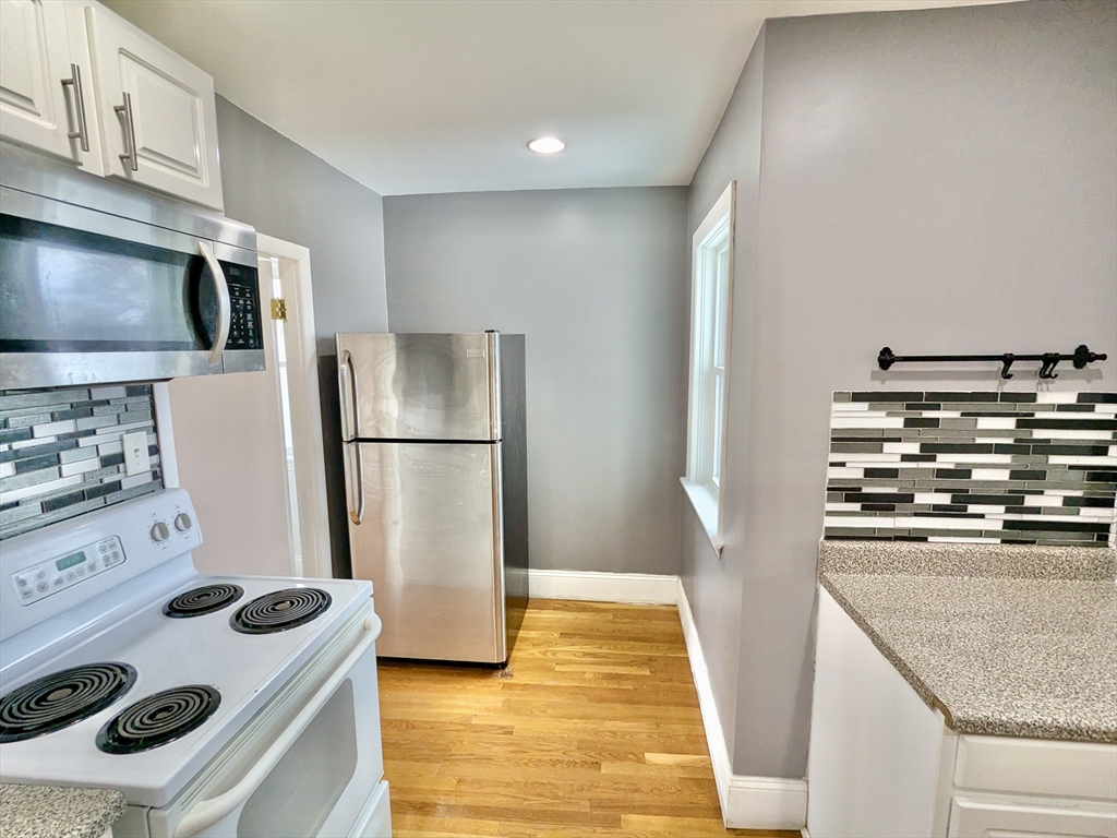 161 Webster Street, Unit 2 Malden, MA 02148 - Photo 2 of 15 a kitchen with a refrigerator and a stove