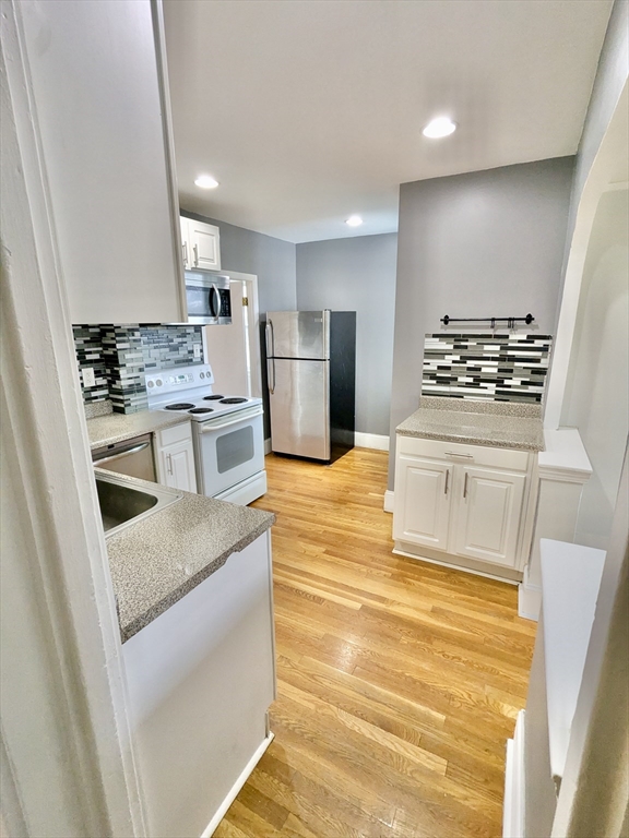 161 Webster Street, Unit 2 Malden, MA 02148 - Photo 3 of 15 a kitchen with stainless steel appliances granite countertop a stove a sink and a refrigerator