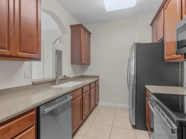 a kitchen with stainless steel appliances granite countertop a refrigerator and a sink