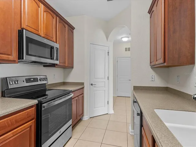 a kitchen with stainless steel appliances granite countertop a stove microwave and sink