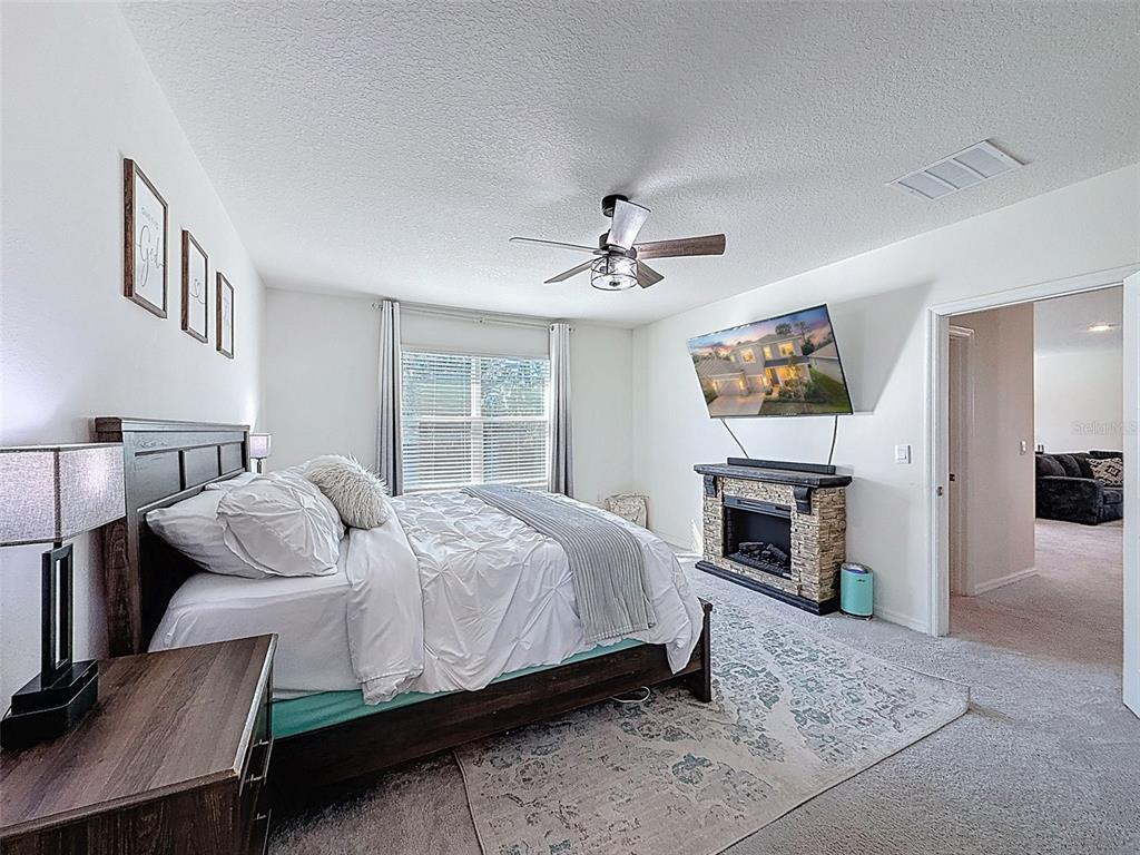 3797 Autumn Amber Dr Spring Hill Spring Hill, FL 34609 - Photo 23 of 44 a bedroom with a bed and a fireplace