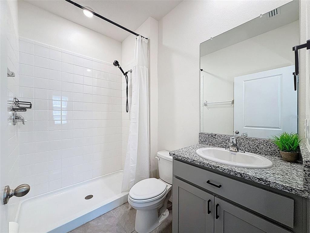 3797 Autumn Amber Dr Spring Hill Spring Hill, FL 34609 - Photo 30 of 44 a bathroom with a granite countertop sink toilet and shower