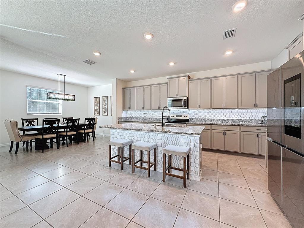 3797 Autumn Amber Dr Spring Hill Spring Hill, FL 34609 - Photo 7 of 44 a kitchen with cabinets and chairs
