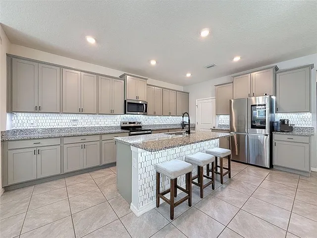 a large kitchen with stainless steel appliances lots of counter top space