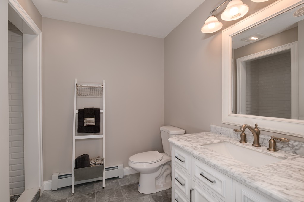 15 Winifreds Way Rutland, MA 01543 - Photo 20 of 30 a bathroom with a granite countertop toilet sink and mirror