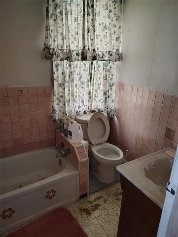 a bathroom with a granite countertop toilet a sink and bathtub