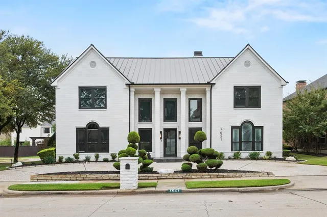 a front view of a house with garden and tree