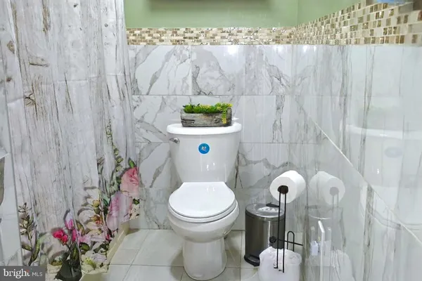 a bathroom with a toilet and a shower curtain