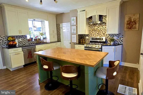 a kitchen with stainless steel appliances granite countertop a stove a sink and a refrigerator