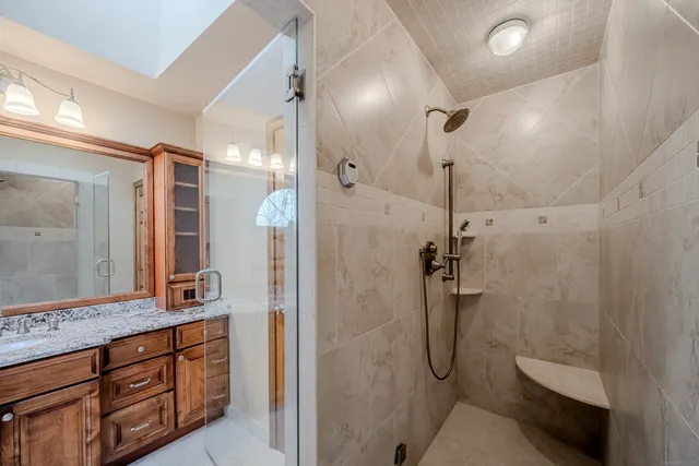 a bathroom with a shower sink and mirror