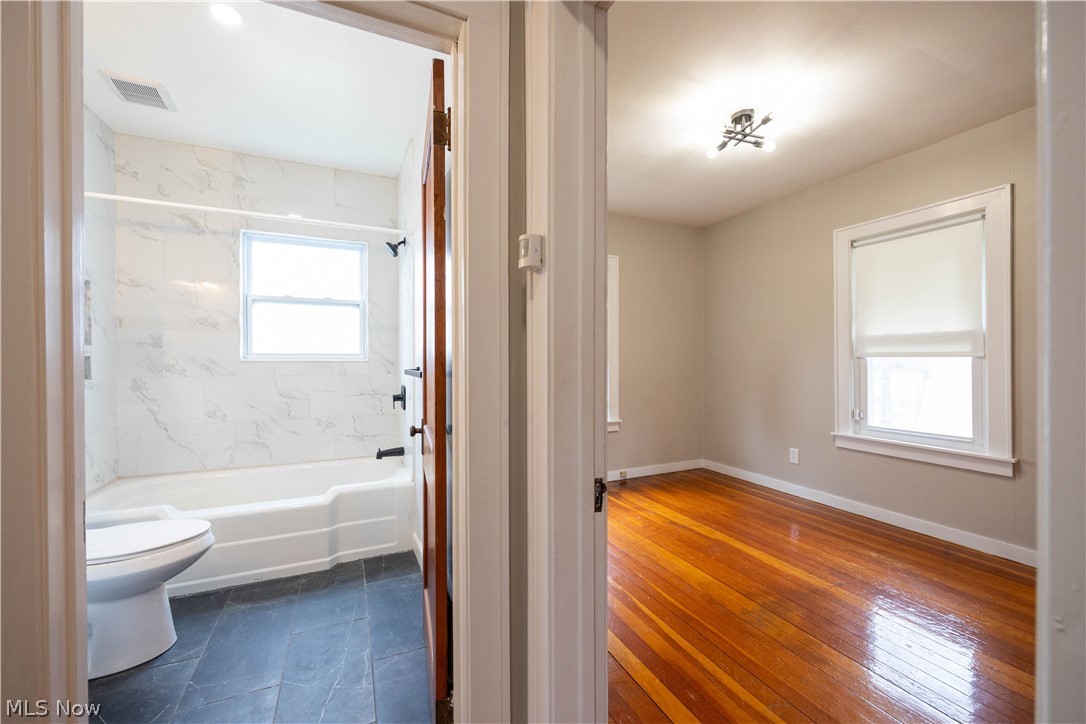 14474 Pease Road Maple Heights, OH 44137 - Photo 18 of 50 Bathroom featuring plenty of natural light, toilet, tiled shower / bath, and tile flooring