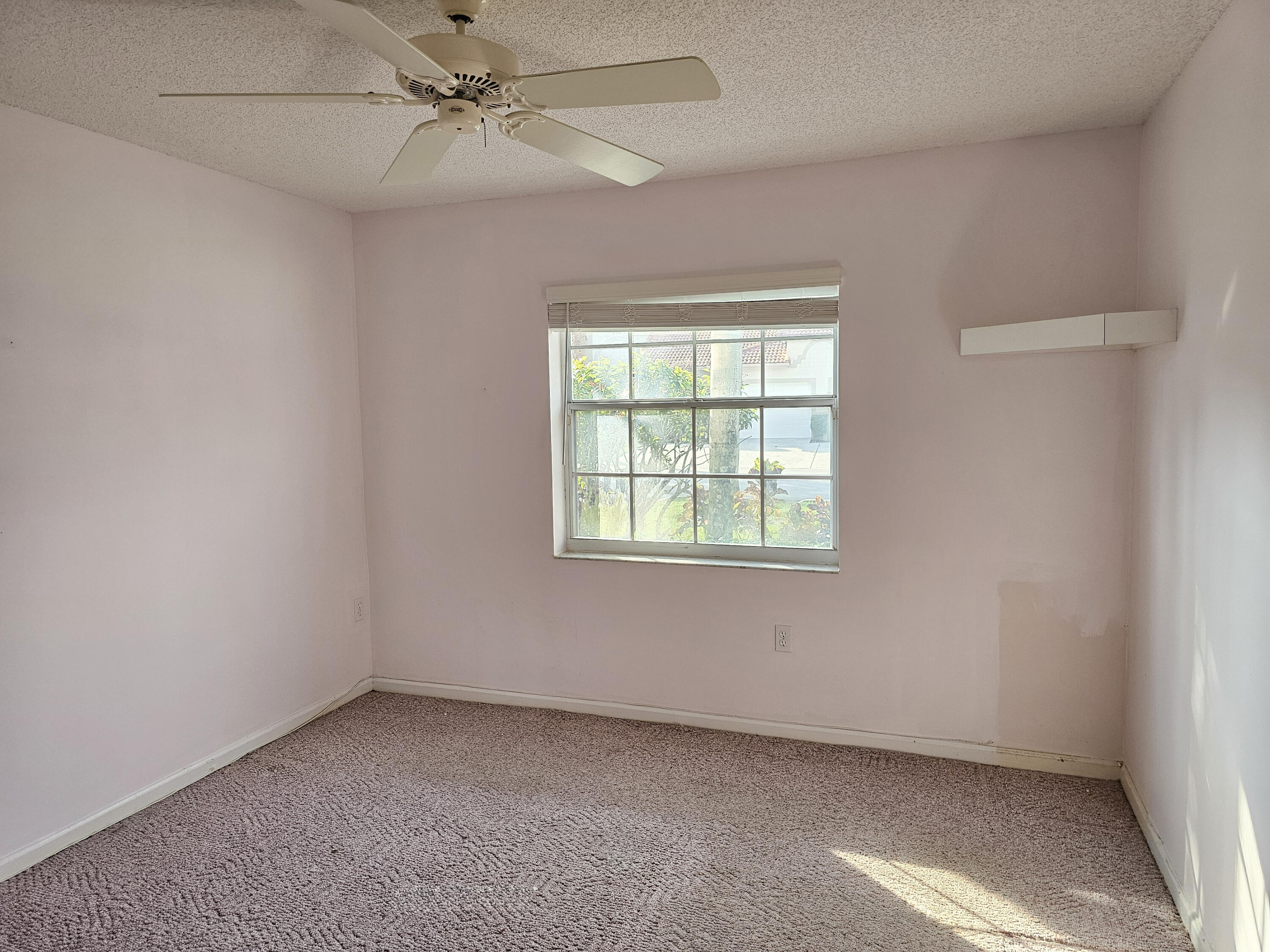 9963 Seacrest Circle, Unit 101 Boynton Beach, FL 33437 - Photo 19 of 27 an empty room with a window and a fan