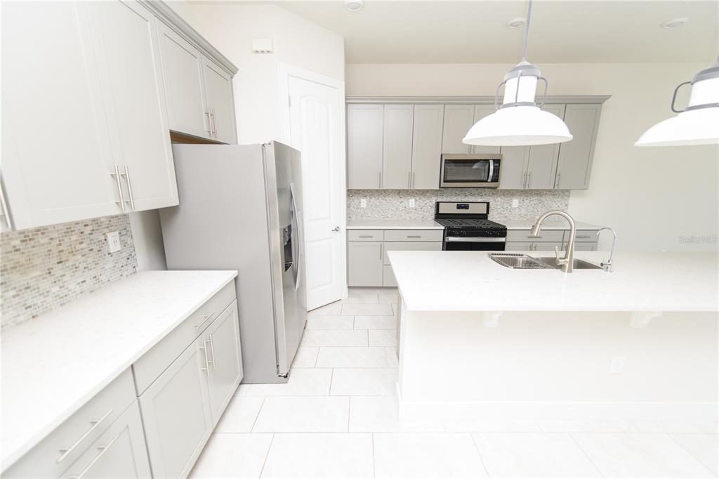 10746 Pahokee Beach Place Orlando, FL 32827 - Photo 10 of 67 a kitchen with stainless steel appliances granite countertop a sink stove and refrigerator