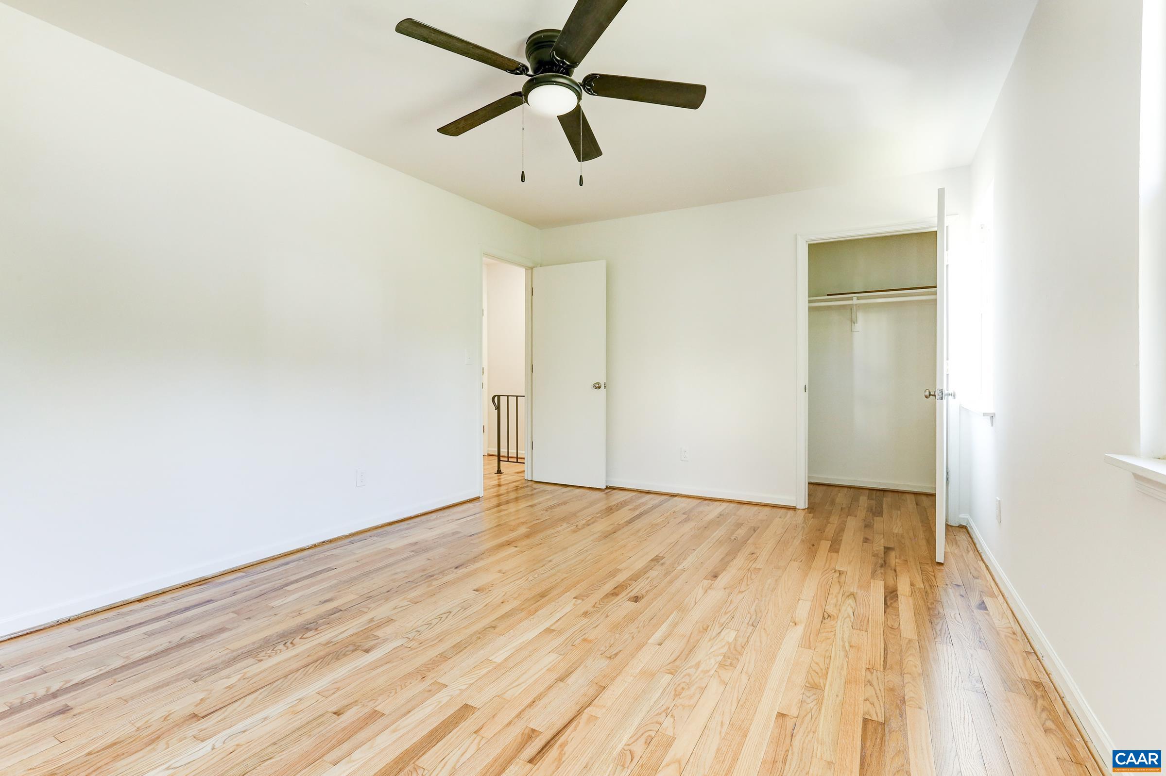 605 Bailey Road Charlottesville, VA 22903 - Photo 15 of 25 an empty room with wooden floor and a ceiling fan