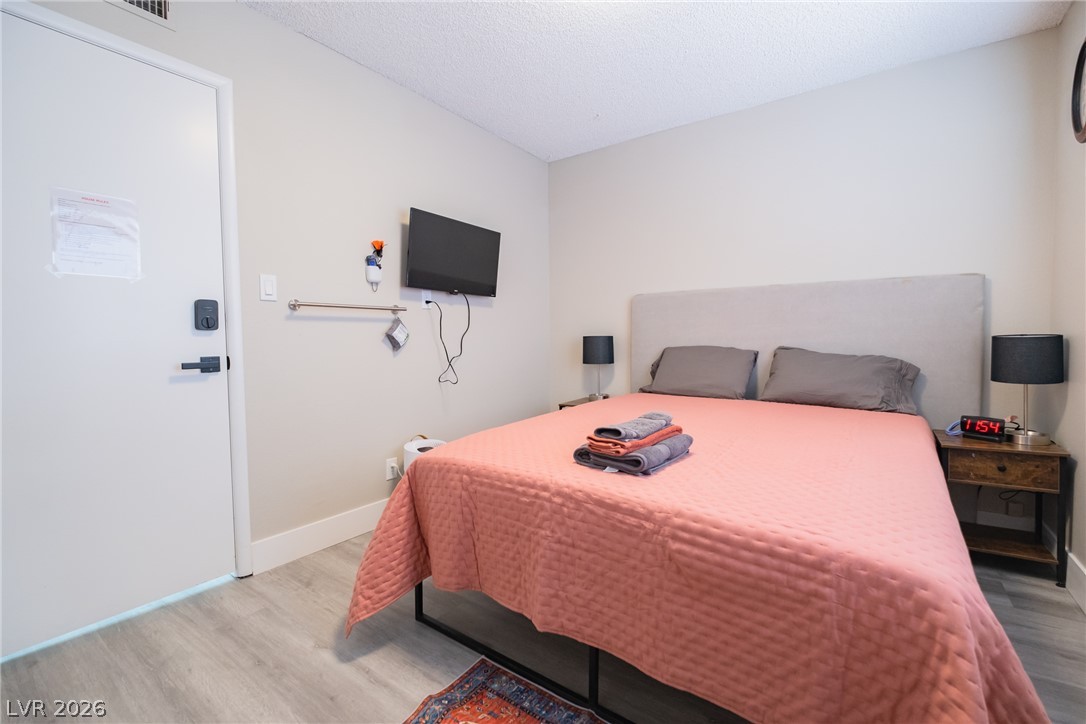6356 West Viking Road Las Vegas, NV 89103 - Photo 44 of 51 Smooth wood-look flooring and clean neutral walls define this comfortable sleeping space.