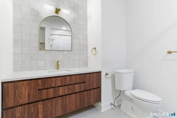 a bathroom with a toilet a sink and mirror