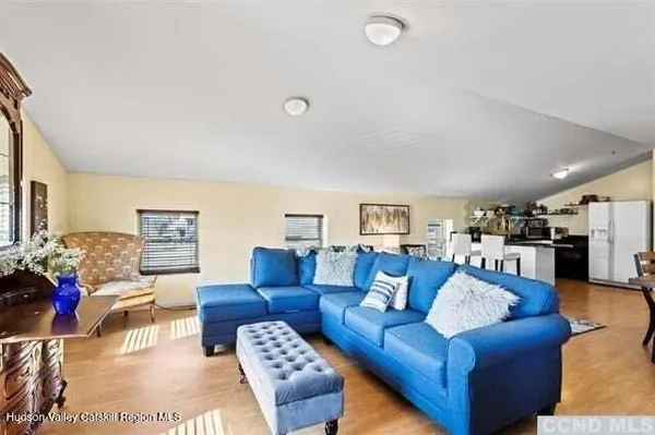a living room with furniture kitchen view and a large window