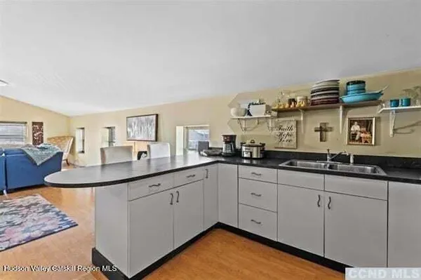 a kitchen with granite countertop a sink and white cabinets