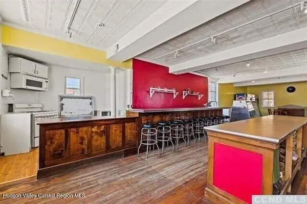 a room with stainless steel appliances kitchen island granite countertop a stove a sink and a microwave