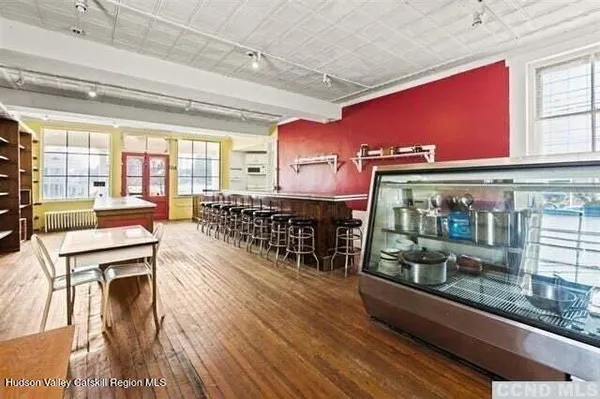 a room with wooden floor table and chairs