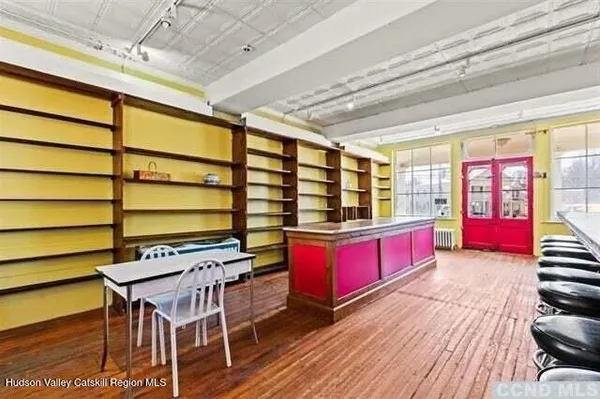 a view of a dining room with furniture a chandelier and wooden floor