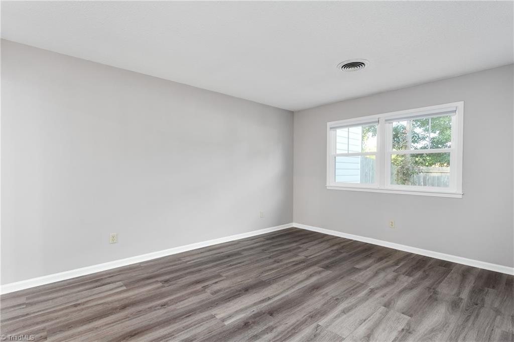 4849 Tower Road, Unit F Greensboro, NC 27410 - Photo 12 of 24 Spacious Primary BR was painted and the LV flooring was installed in 2021.