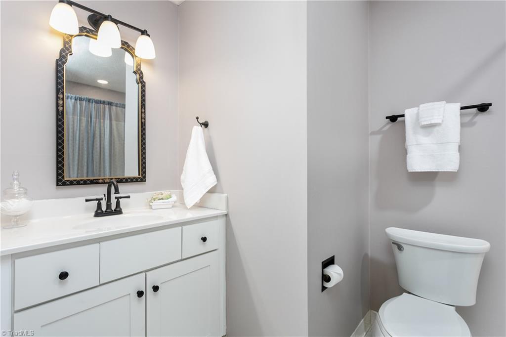 4849 Tower Road, Unit F Greensboro, NC 27410 - Photo 18 of 24 Hall Bath with updated vanity, countertop, fixtures, mirror and lighting