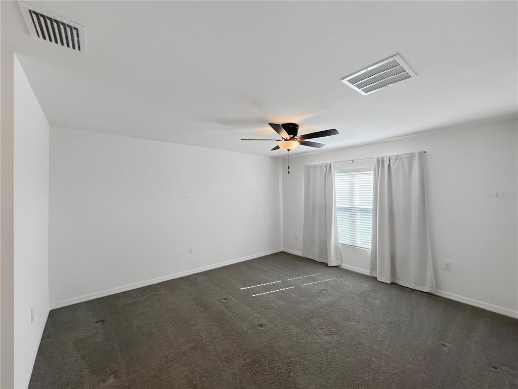 5563 Southwest 43rd Court Ocala, FL 34474 - Photo 23 of 51 an empty room with windows and fan