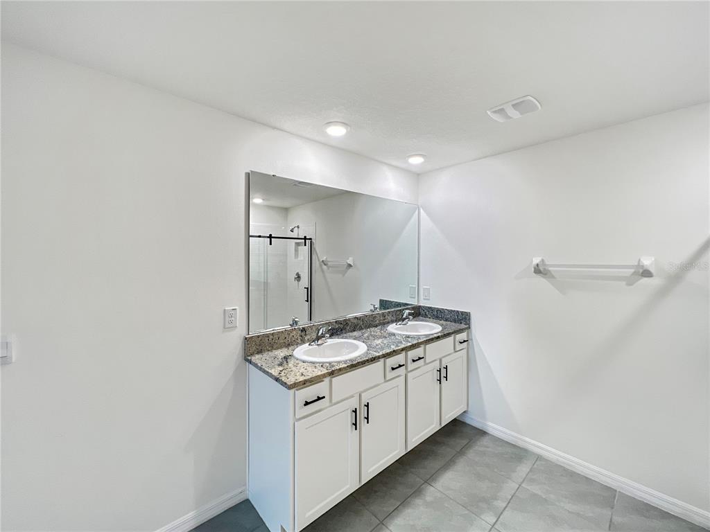 5563 Southwest 43rd Court Ocala, FL 34474 - Photo 26 of 51 a bathroom with a granite countertop sink and a mirror