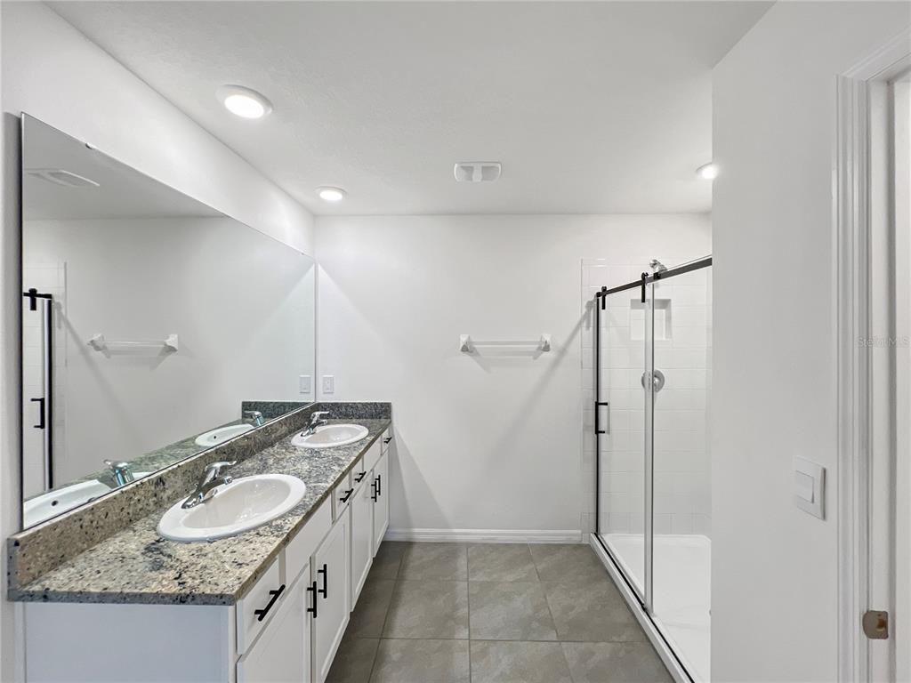 5563 Southwest 43rd Court Ocala, FL 34474 - Photo 27 of 51 a bathroom with a granite countertop double vanity sink and mirror