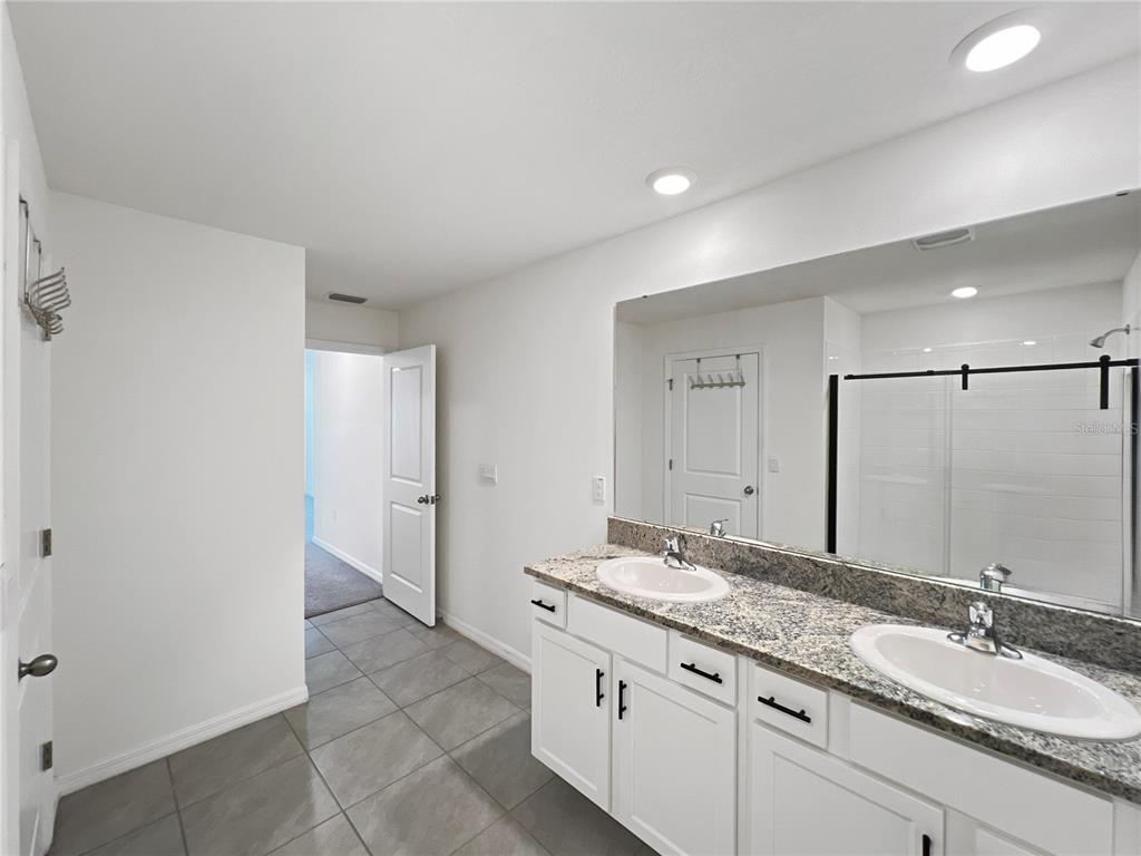 5563 Southwest 43rd Court Ocala, FL 34474 - Photo 28 of 51 a bathroom with a granite countertop sink and a mirror