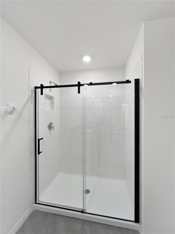 5563 Southwest 43rd Court Ocala, FL 34474 - Photo 29 of 51 a bathroom with a glass shower door