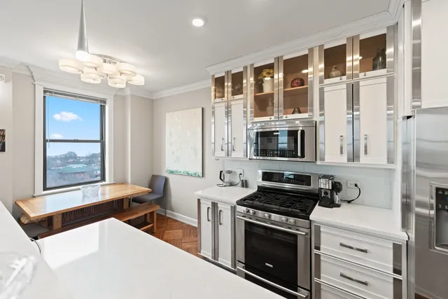 a kitchen with stainless steel appliances a stove top oven a sink a counter space and cabinets