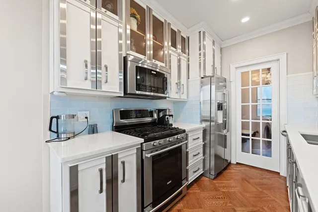 a kitchen with stainless steel appliances a stove a sink and a microwave