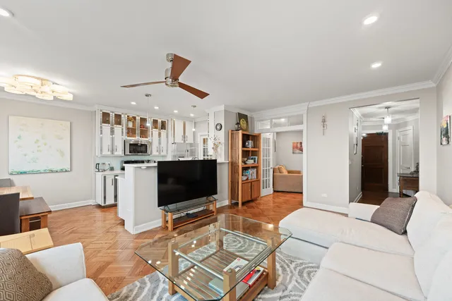 a living room with furniture a flat screen tv and kitchen view