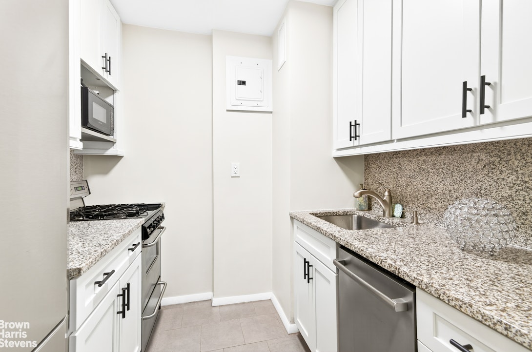 520 East 72nd Street, Unit 5F Manhattan, NY 10021 - Photo 5 of 16 a kitchen with granite countertop a sink stove and cabinets