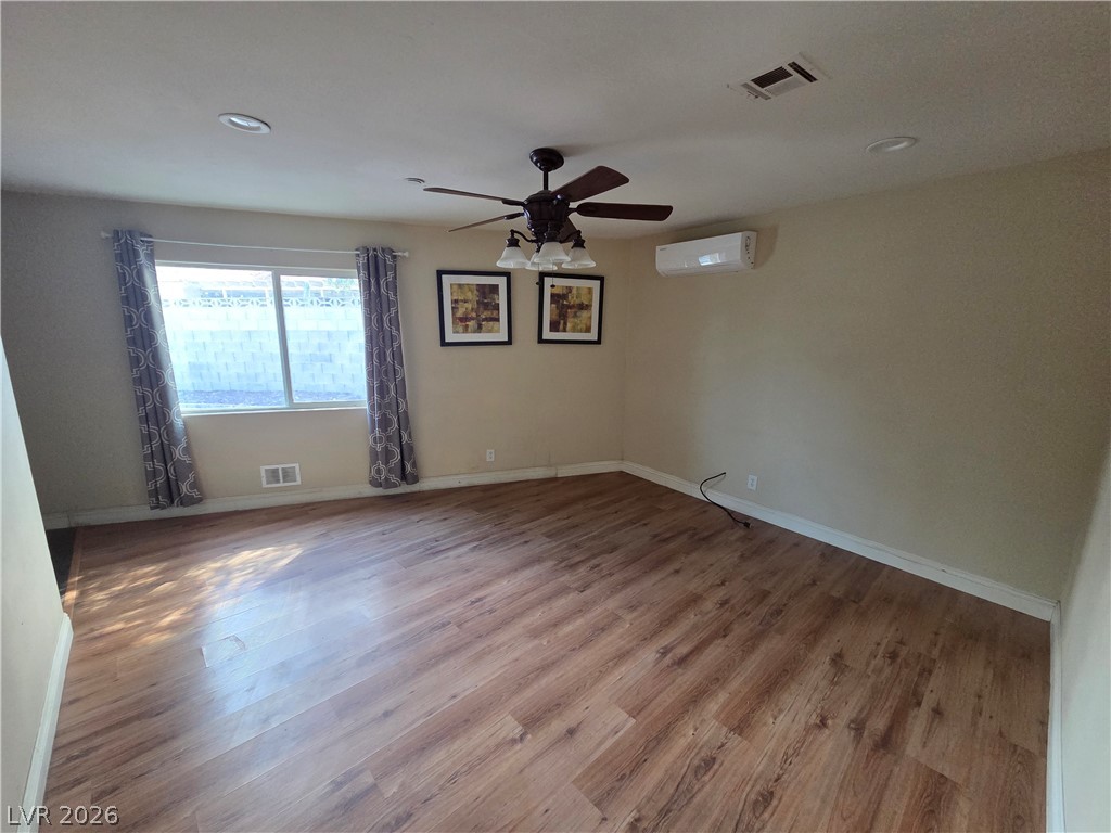 3381 Westwind Road Las Vegas, NV 89146 - Photo 32 of 52 A well-lit living space features rich hardwood flooring and a functional ceiling fan.