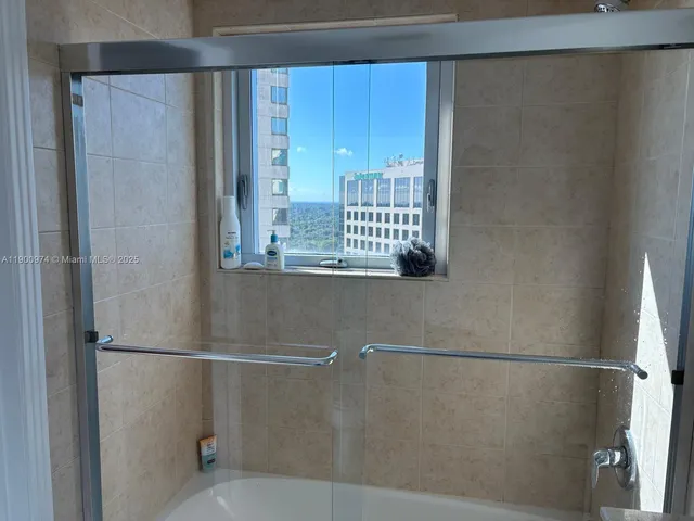 a close view of a bathroom with a shower and a sink