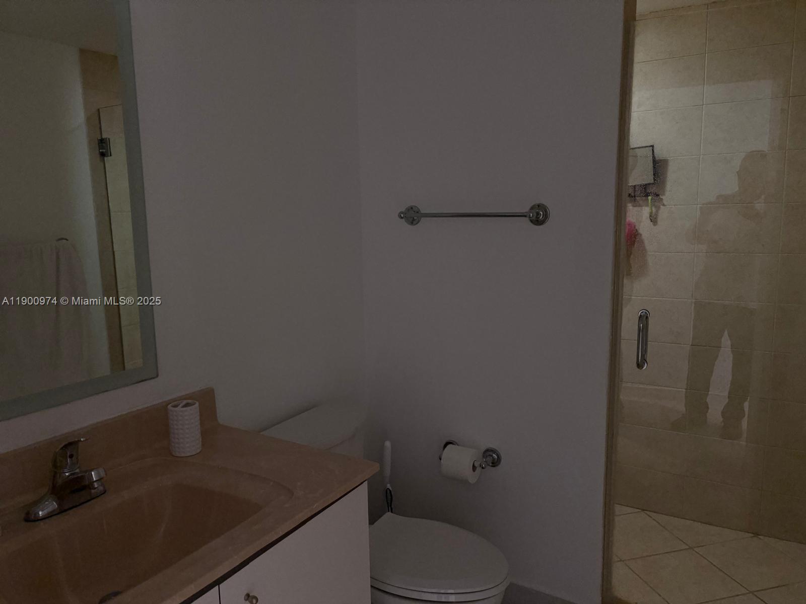 9055 Southwest 73rd Court, Unit 1806 Miami, FL 33156 - Photo 17 of 23 a bathroom with a granite countertop toilet and sink