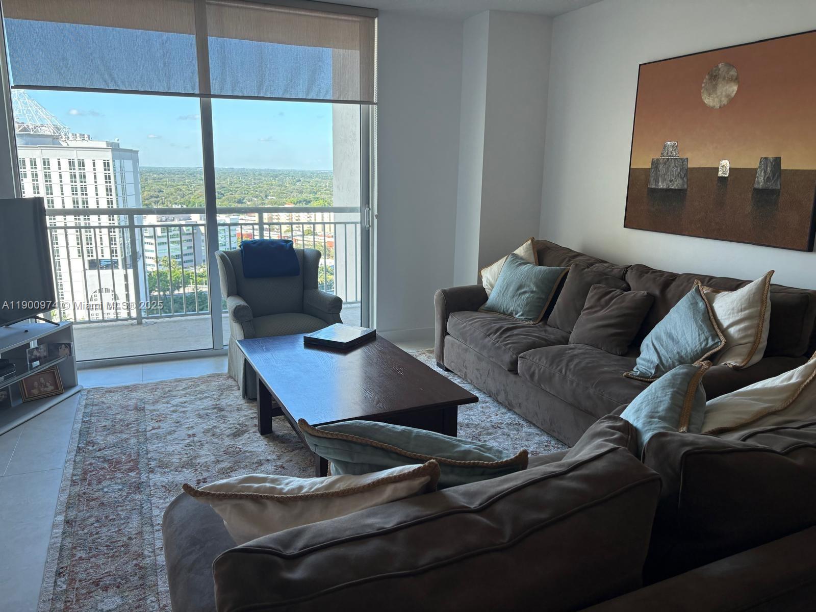9055 Southwest 73rd Court, Unit 1806 Miami, FL 33156 - Photo 3 of 23 a living room with furniture and a flat screen tv