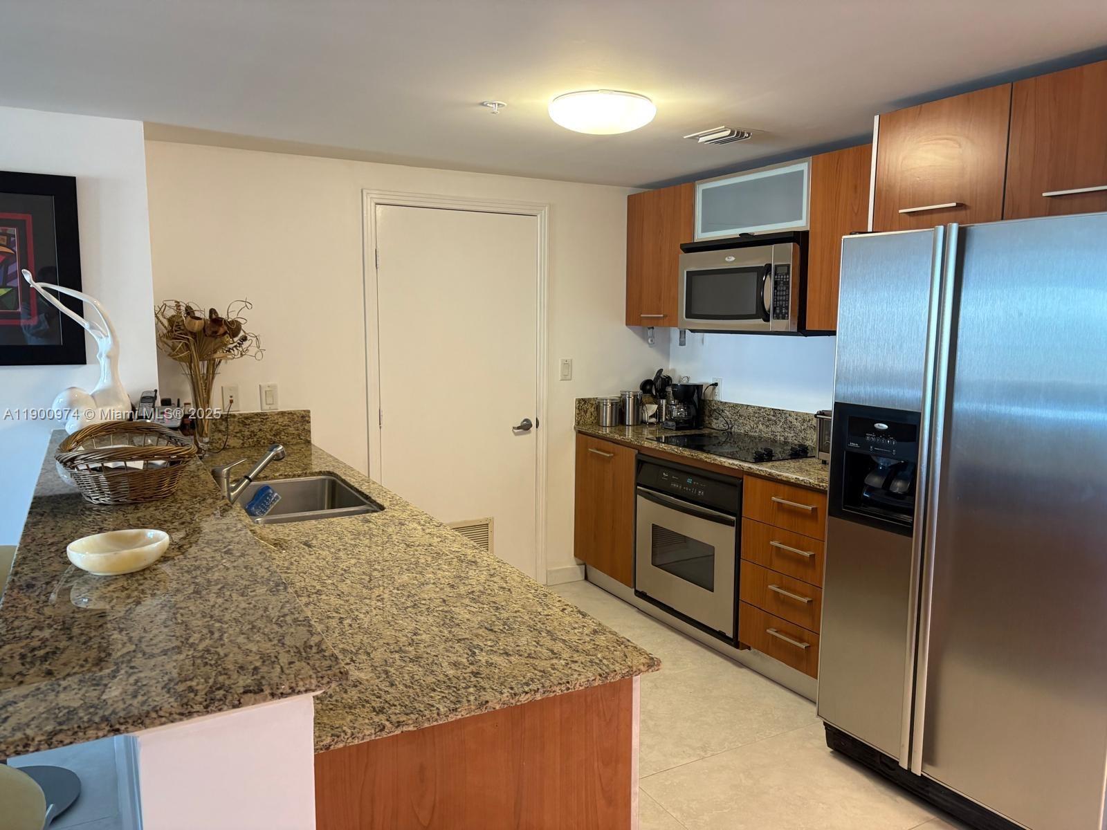 9055 Southwest 73rd Court, Unit 1806 Miami, FL 33156 - Photo 8 of 23 a kitchen with stainless steel appliances granite countertop a sink stove and refrigerator