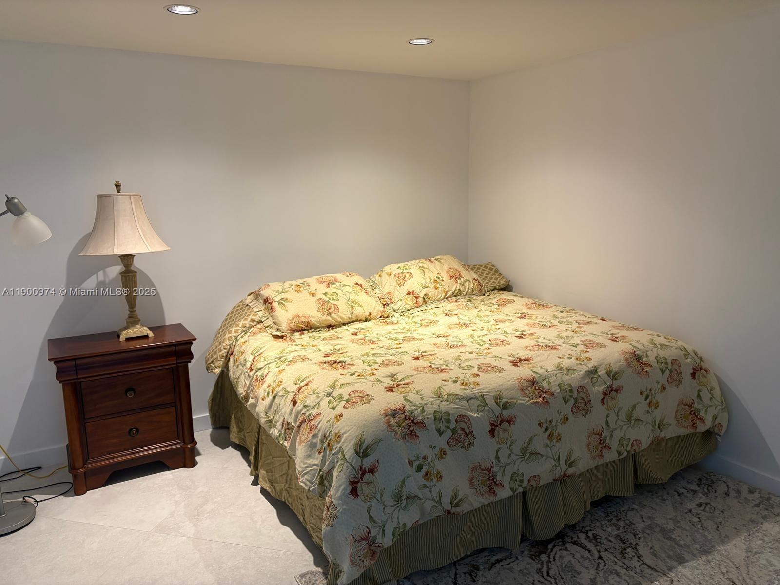 9055 Southwest 73rd Court, Unit 1806 Miami, FL 33156 - Photo 10 of 23 a bed sitting in a bedroom next to a lamp