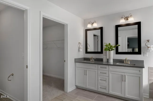a bathroom with double vanity sinks and a mirror