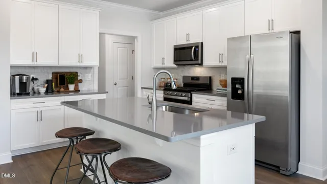 a kitchen with granite countertop a counter space a refrigerator and a stove top oven