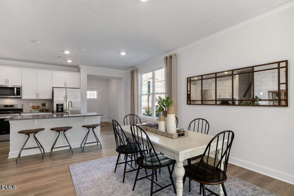 Undisclosed Address Fuquay-Varina, NC 27526 - Photo 6 of 28 a view of a dining room with furniture and wooden floor