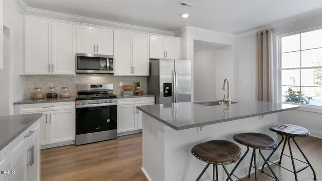 a kitchen with stainless steel appliances granite countertop a stove a sink a microwave and a refrigerator