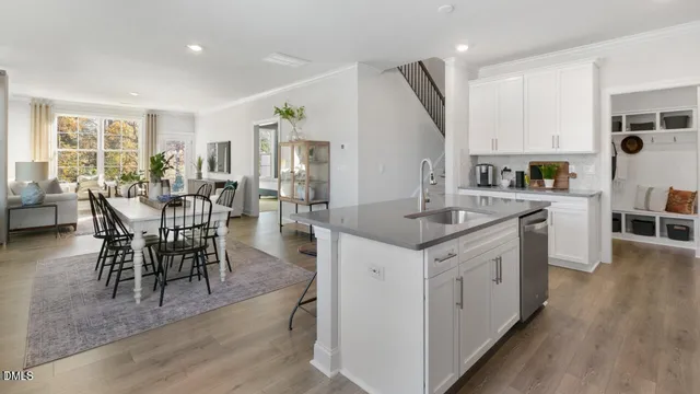 a kitchen with stainless steel appliances granite countertop a table chairs sink and cabinets