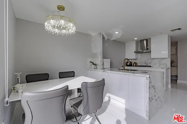 a large kitchen with kitchen island a sink a stove a dining table and chairs